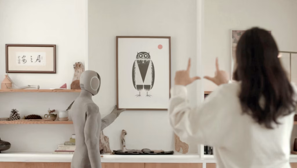 Un robot Neo Gamma en train d'aider une femme dans sa maison